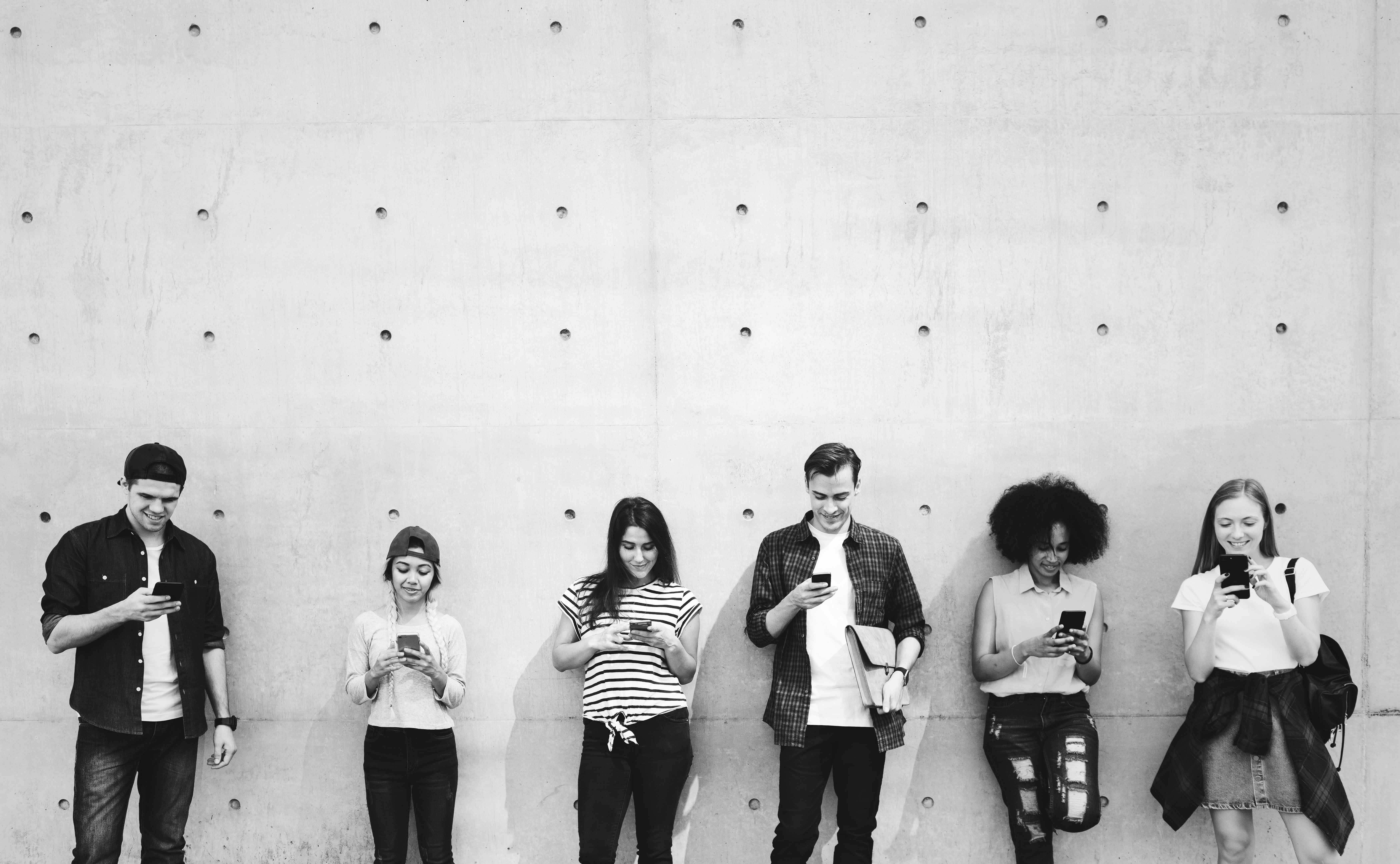 freunde die zusammen smartphones verwenden und kuehlen klein